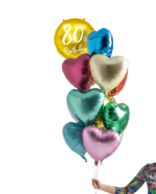 Colorful heart-shaped balloons with a '80th Birthday' balloon held by a person on a white background
