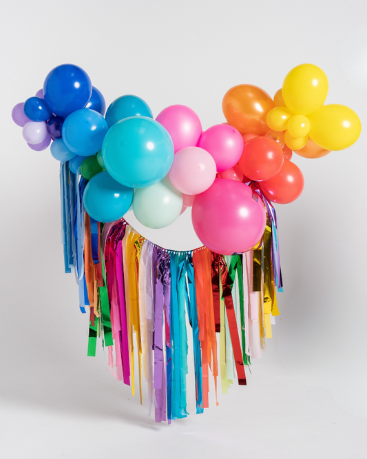 Colorful balloon arch with tassels on a white background