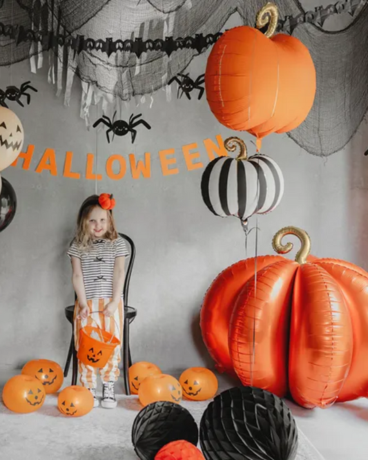 Halloween-themed room with balloons, decorations.