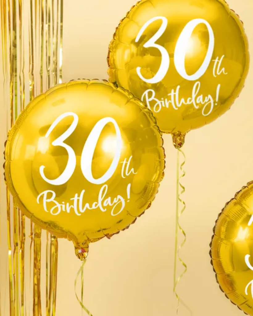 Gold '30th Birthday!' balloons with gold tinsel on a beige background