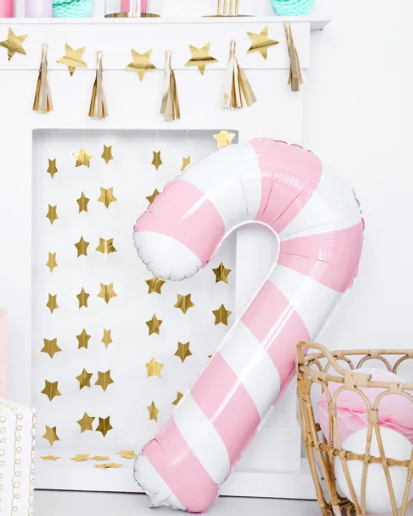 Pink and white striped balloon shaped like a candy cane against a gold star and tassel backdrop.