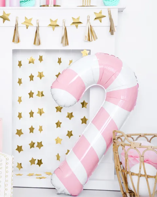 Pink and white striped balloon shaped like a candy cane against a gold star and tassel backdrop.