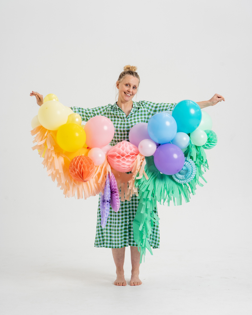 Person wearing a colourful pastel rainbow fancy garland on a white background