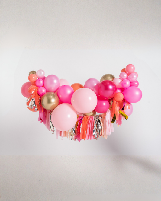 Balloon crown with pink, gold, and orange balloons on a white background