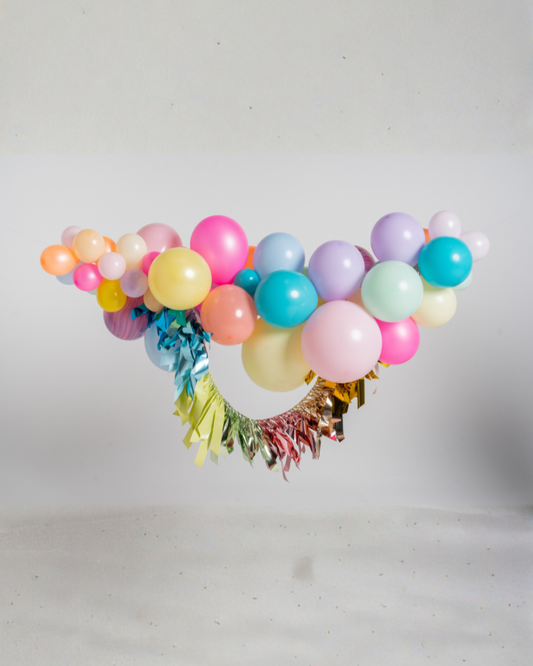 Colorful balloon arch with tassels on a white background