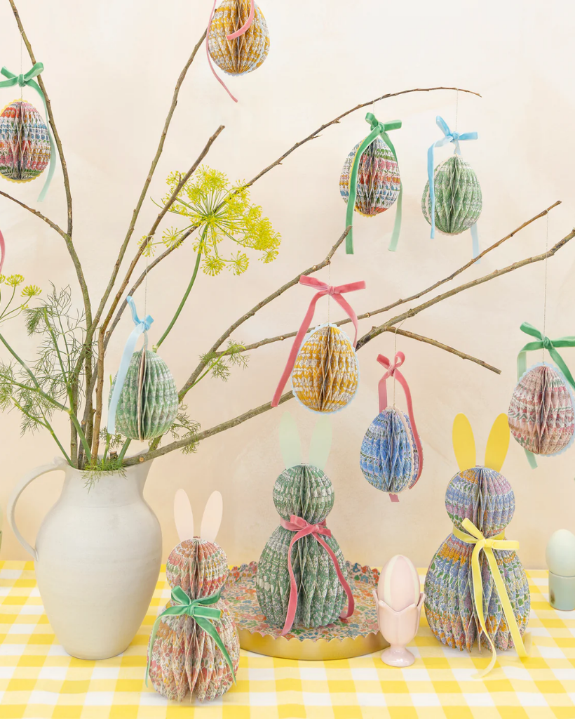 Decorative Easter scene with paper honeycomb eggs and bunnies on a branch.