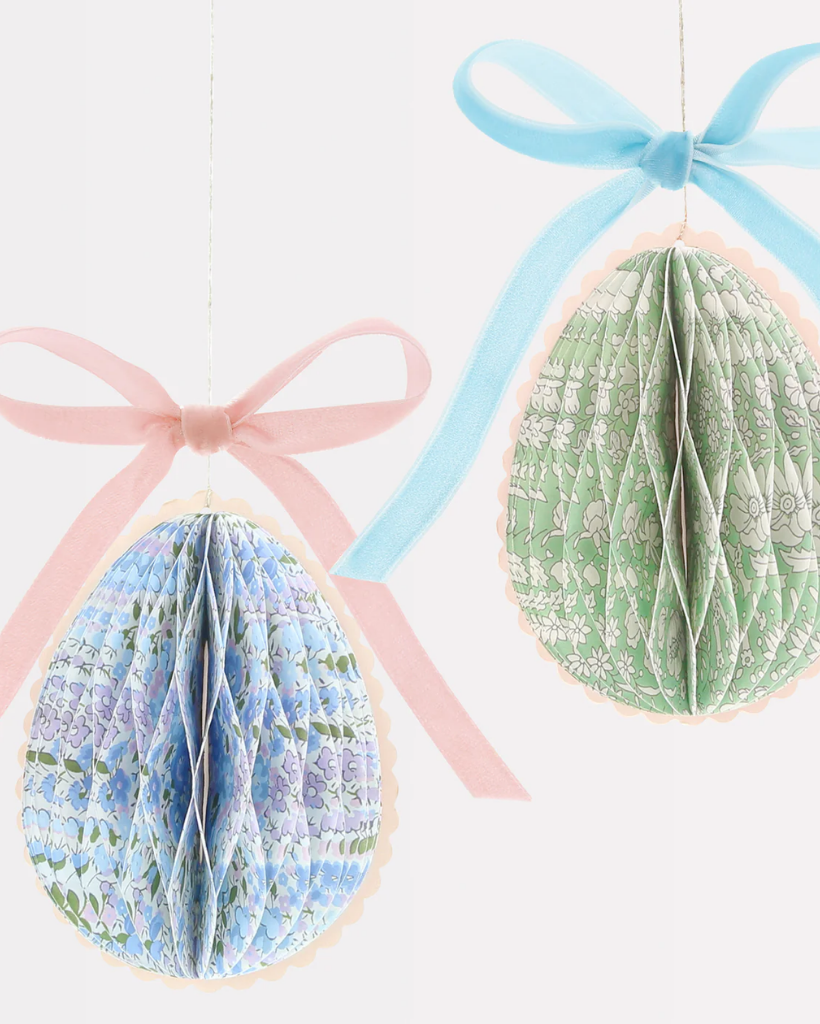 Two decorative paper honeycomb eggs with ribbons.