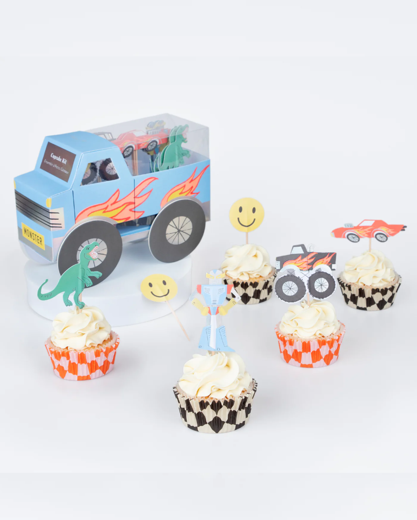 Cupcakes with dinosaur and truck-themed toppers on a white background