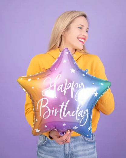 Person holding a star-shaped 'Happy Birthday' balloon against a purple background