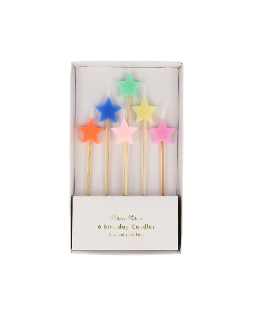 Set of colorful star-shaped birthday candles in a box on a white background
