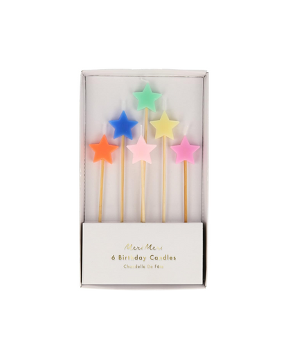 Set of colorful star-shaped birthday candles in a box on a white background