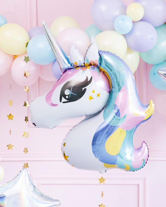 Unicorn-shaped balloon with pastel colors against a pink background