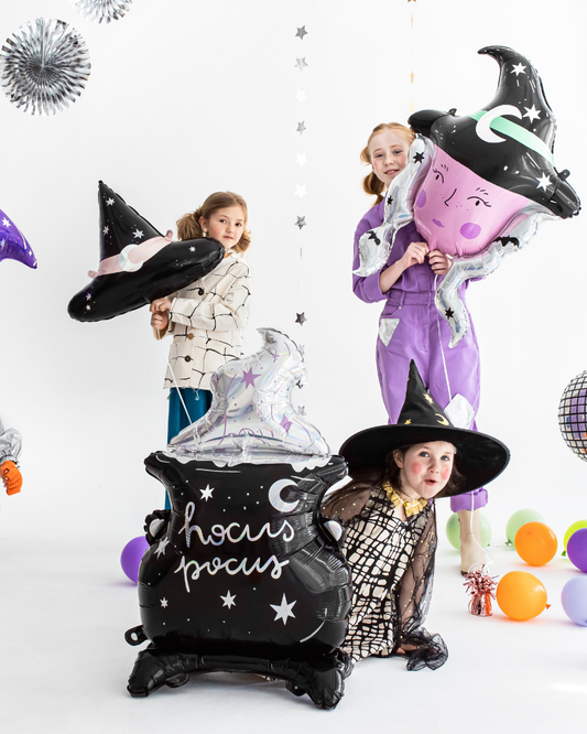 Children in Halloween costumes with witch-themed balloons on a white background
