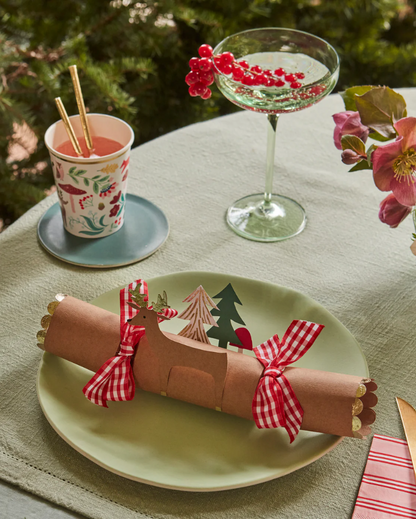 Decorative Christmas cracker on a plate with a festive table setting.