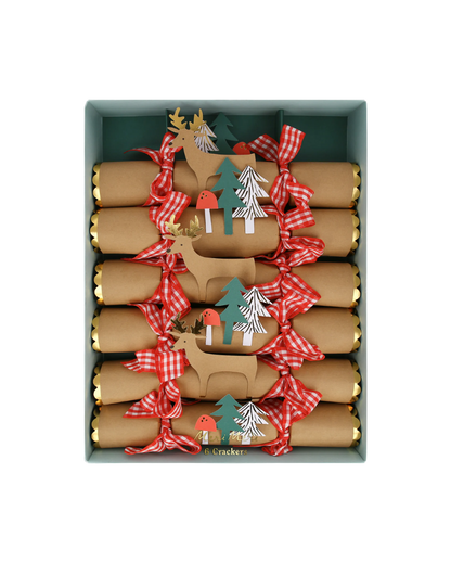 Box of Christmas crackers with reindeer and tree decorations on a white background