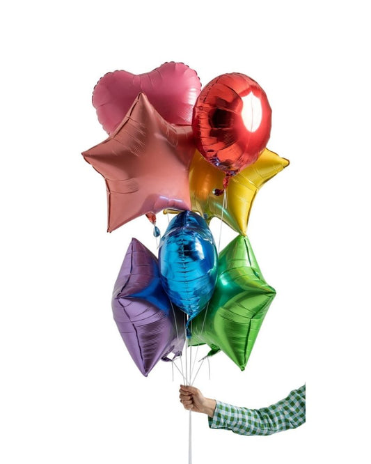 A bouquet of multicolored balloons including stars and round shapes, filled with helium and held by a person.