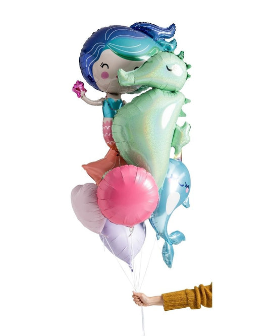A balloon bouquet featuring a mermaid, seahorse, and narwhal with other smaller balloons, all in colorful foil.